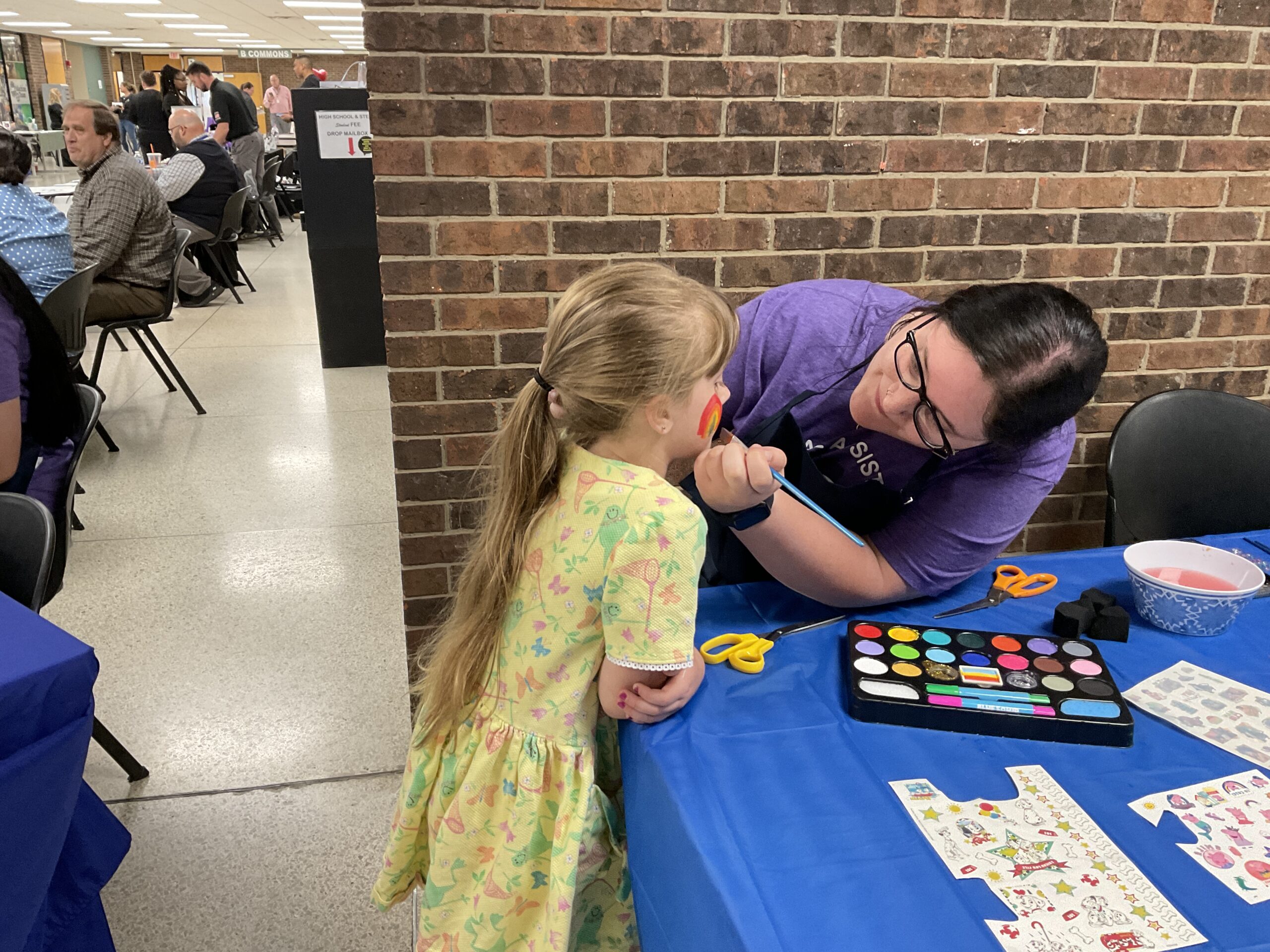 young girl getting face painting at health and safety fair